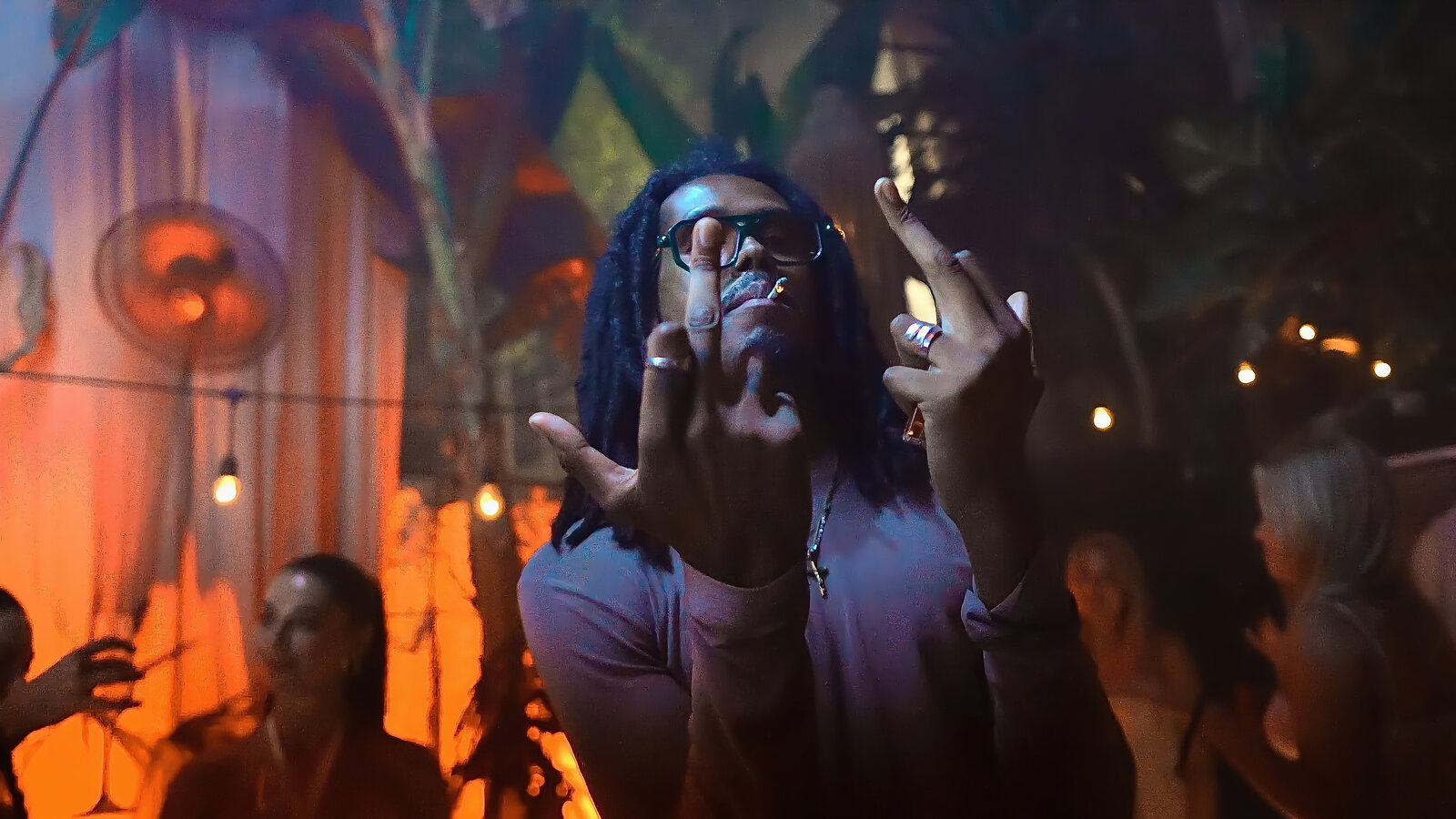 DJ throwing up hands, warm stage lighting