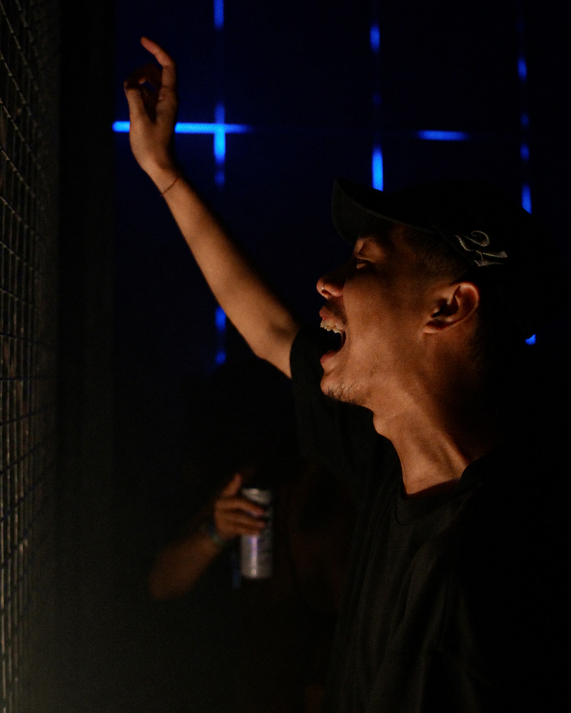 Man cheering with hand raised, blue light