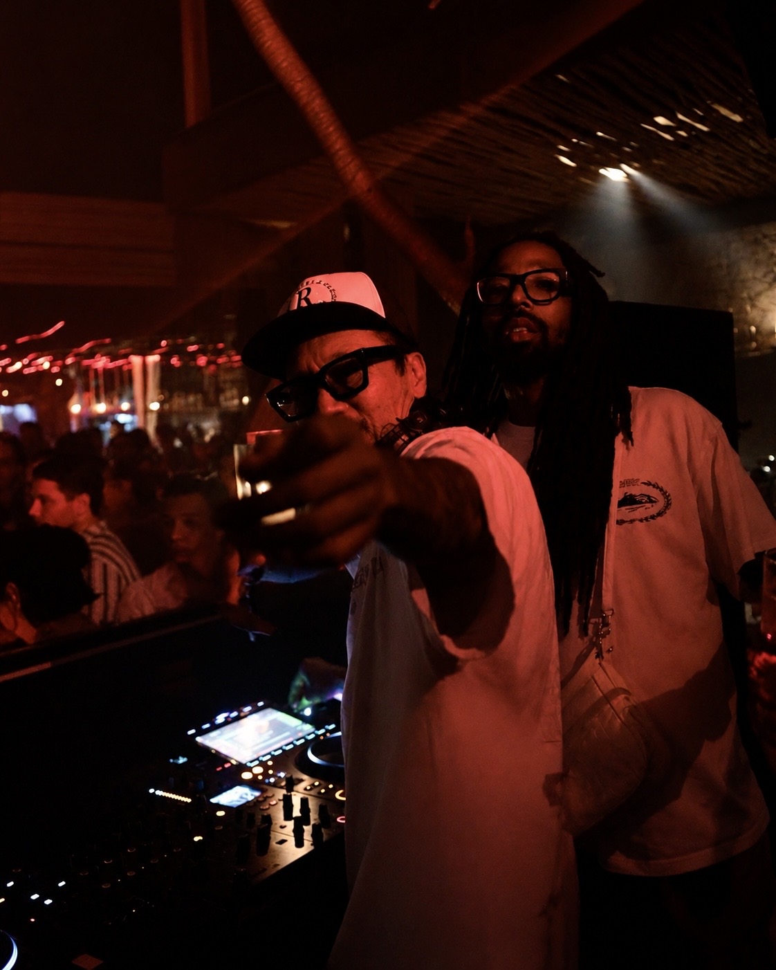 Two men at the DJ booth, red light