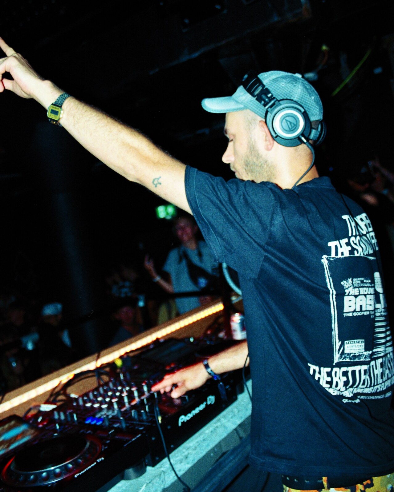 DJ arm raised at the decks, film photo